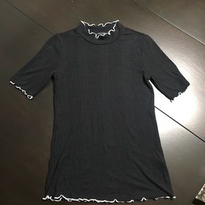A short black turtleneck with white trimming